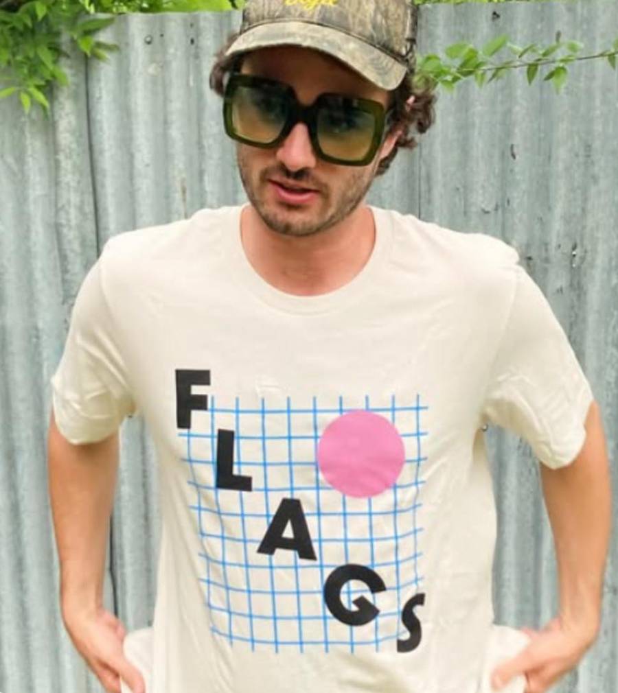 Austin band member wearing a custom-printed cream tee with a 'Flags' grid graphic — printed by Austin Print Co.